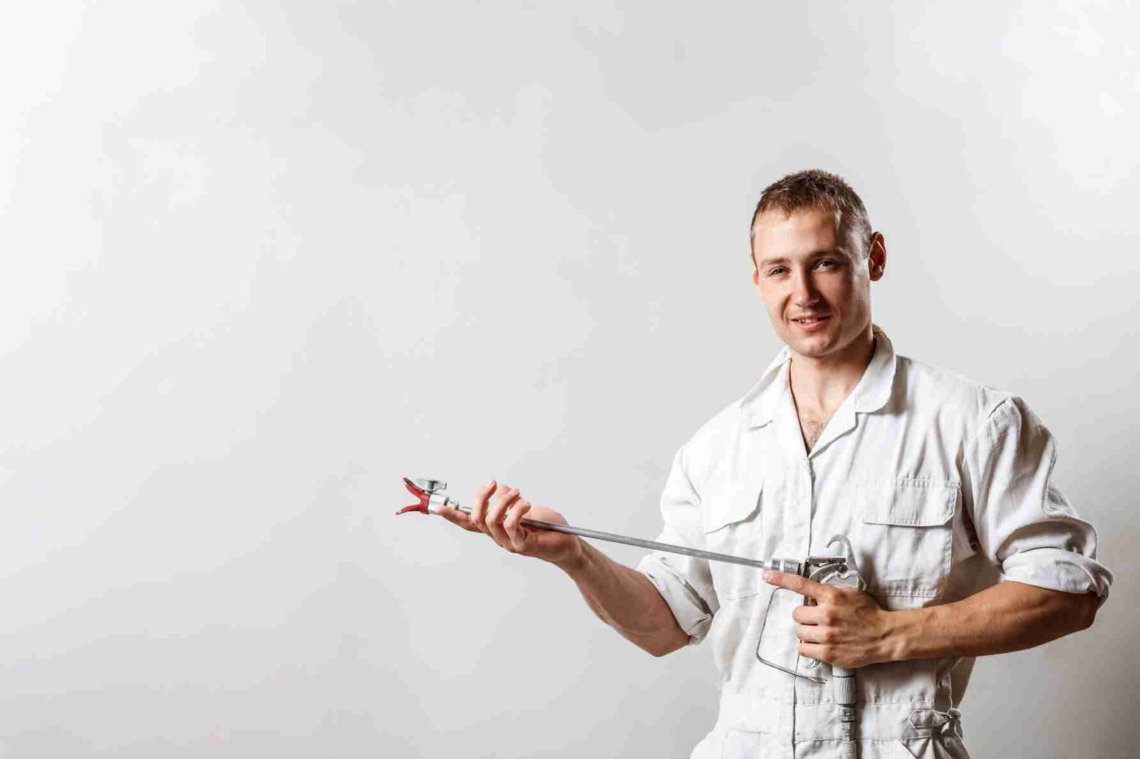 worker holding spray gun white wall 1