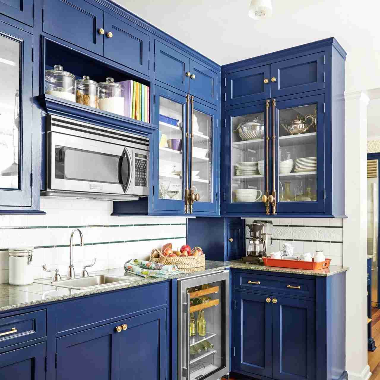 a kitchen with blue cabinets and a microwave